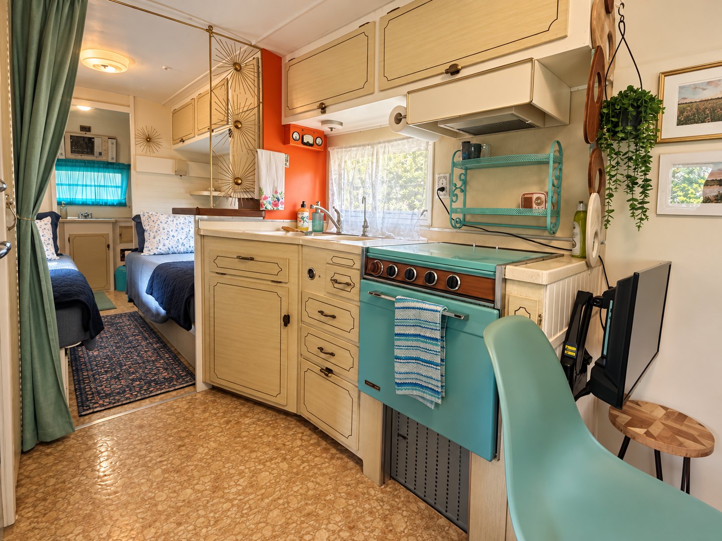 Kitchen with turquoise appliances and an orange wall